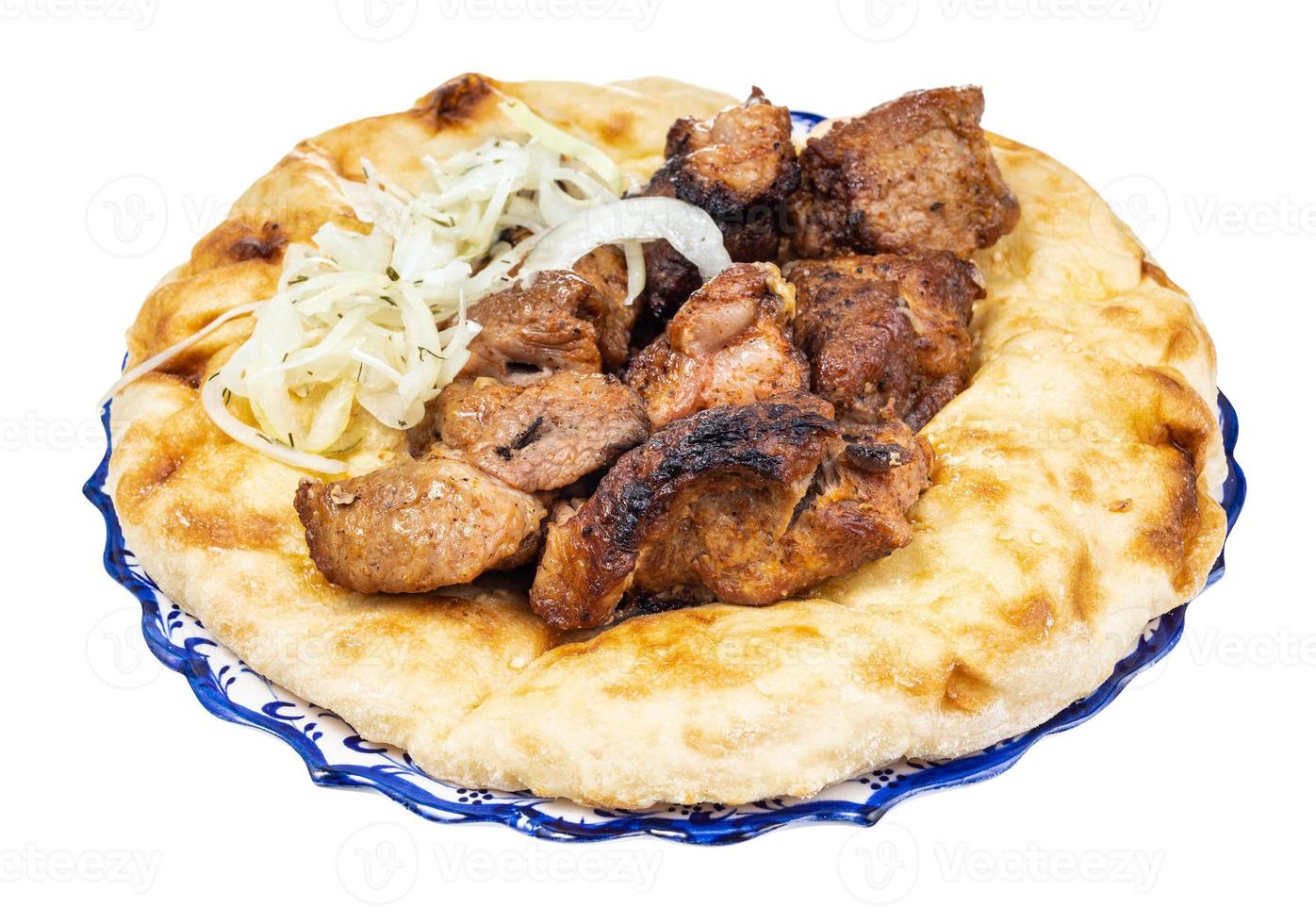 Portion Kebab auf Fladenbrot auf Teller isoliert foto