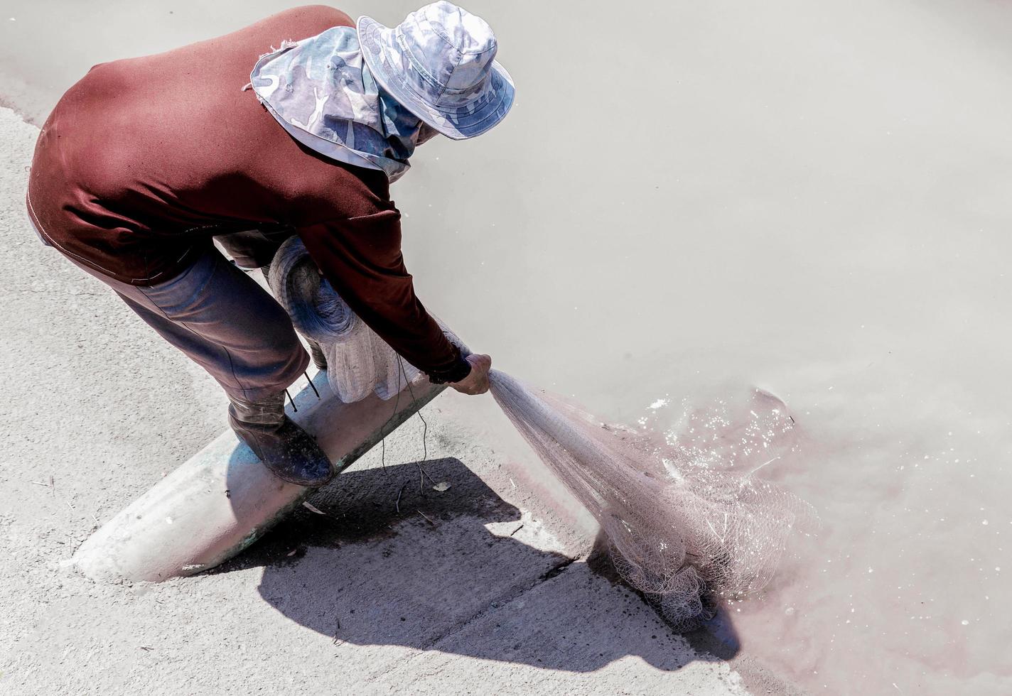 Dorfbewohner fangen Fische entlang des Kanals foto