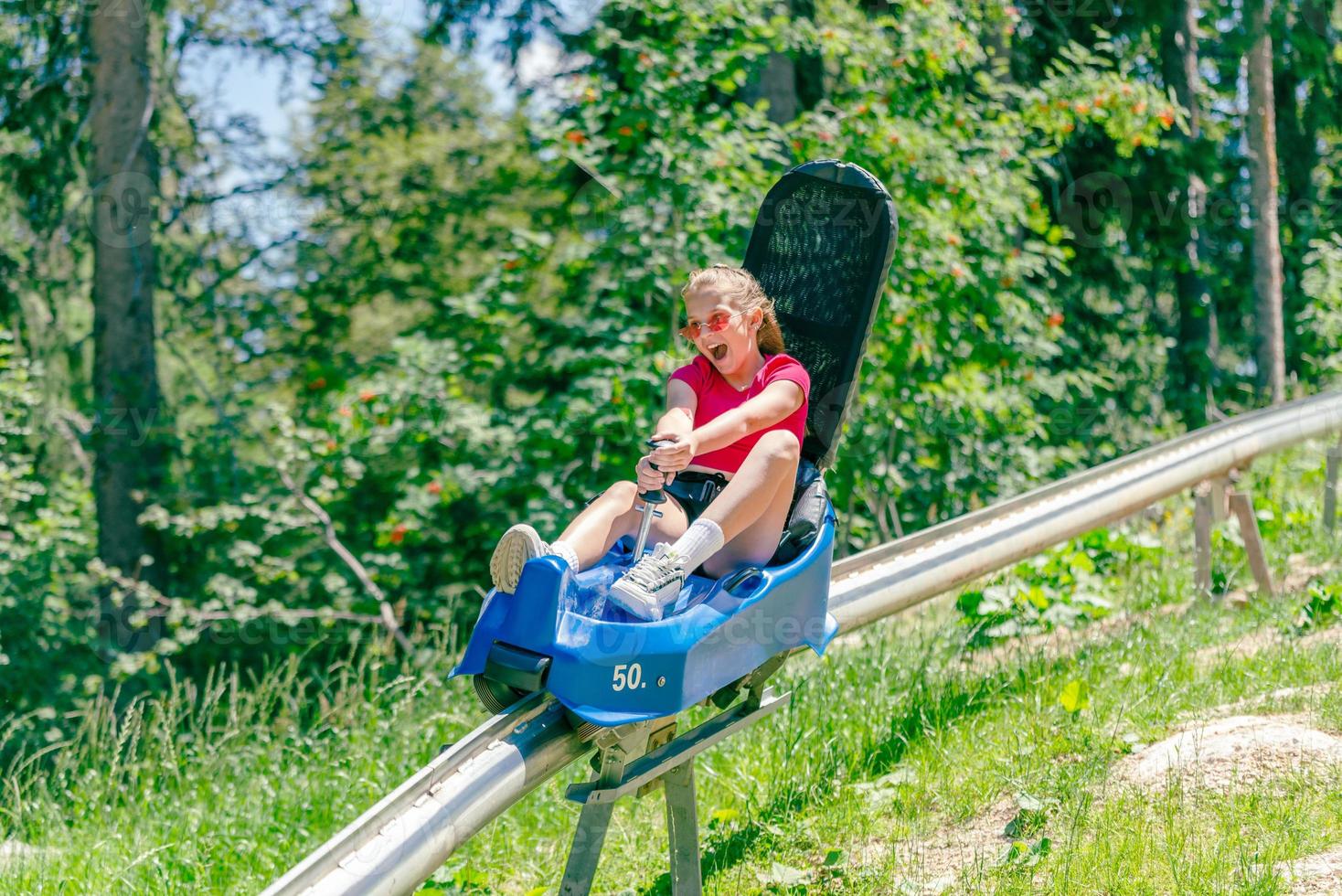 Teenager-Mädchen schreit, wenn sie eine Bergachterbahn hinunterfährt foto