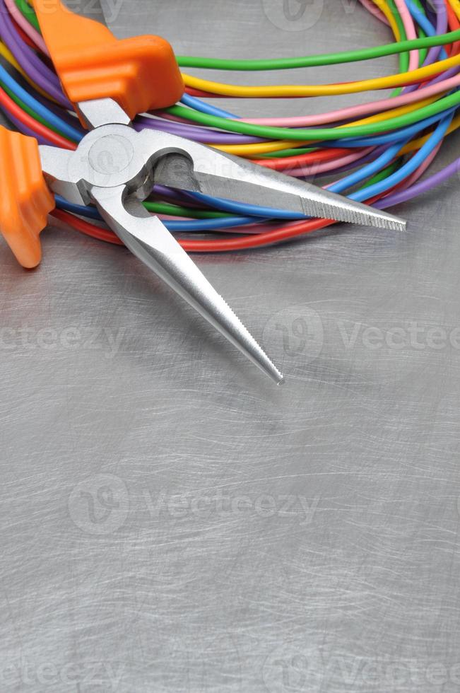 Elektrowerkzeuge und Kabel auf Metalloberfläche mit Platztext foto