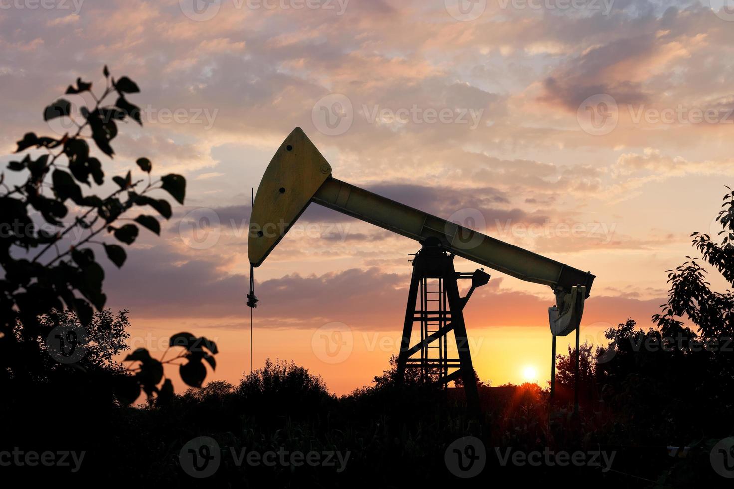 Pumpjack pumpt Öl bei Sonnenuntergang im Sommer foto