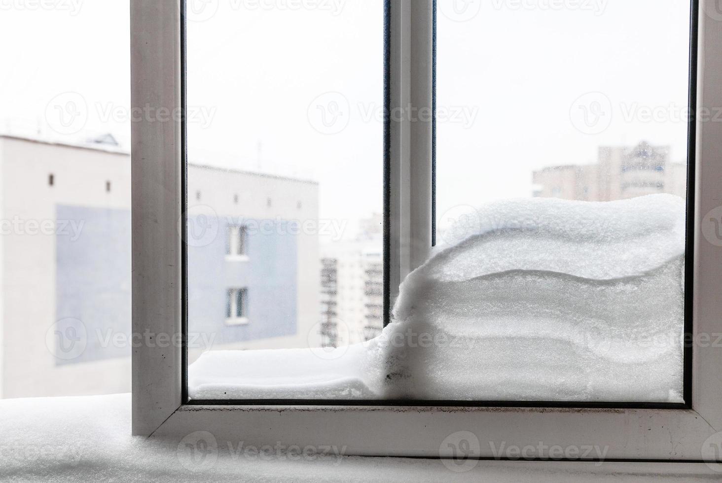 Fenster mit Schneewehe zwischen Rahmen im Winter foto