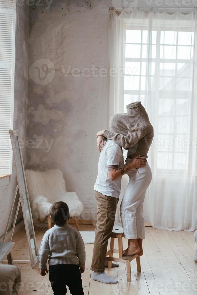 Papa und Mama spielen Verstecken mit ihrem kleinen Sohn foto