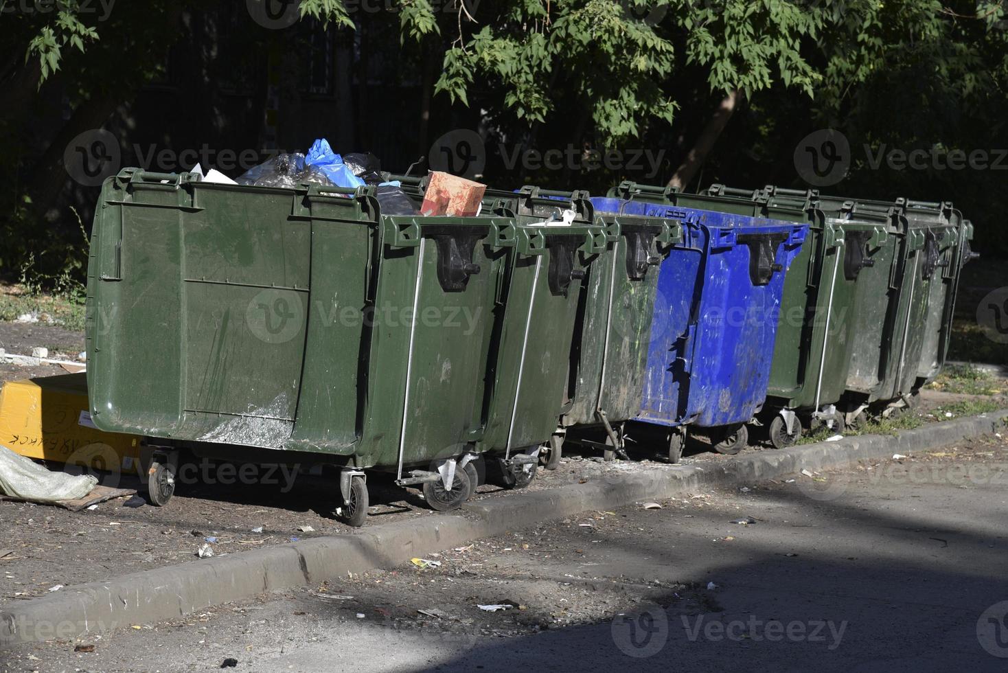 Mülltonnen im Stadtgebiet und eine Deponie. Plastikmüllcontainer im Dorf. foto