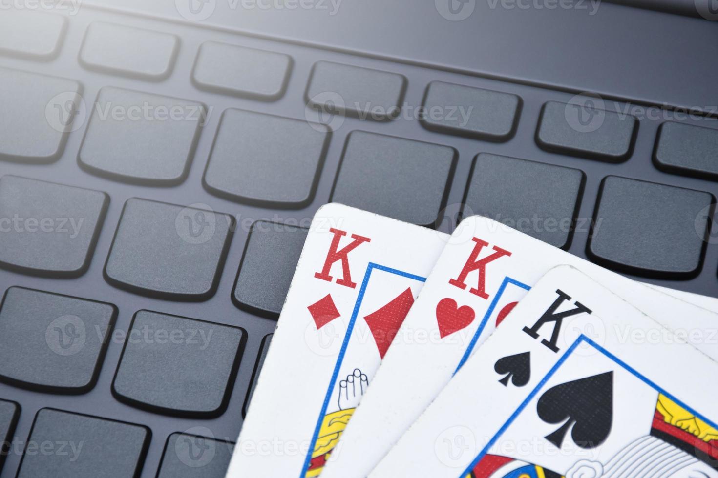 Pokerpapierkarten auf leerer Laptop-Tastatur, weicher und selektiver Fokus, Konzept für das Online-Spielen von Karten mit anderen Menschen zu Hause und Freizeitaktivitäten. foto