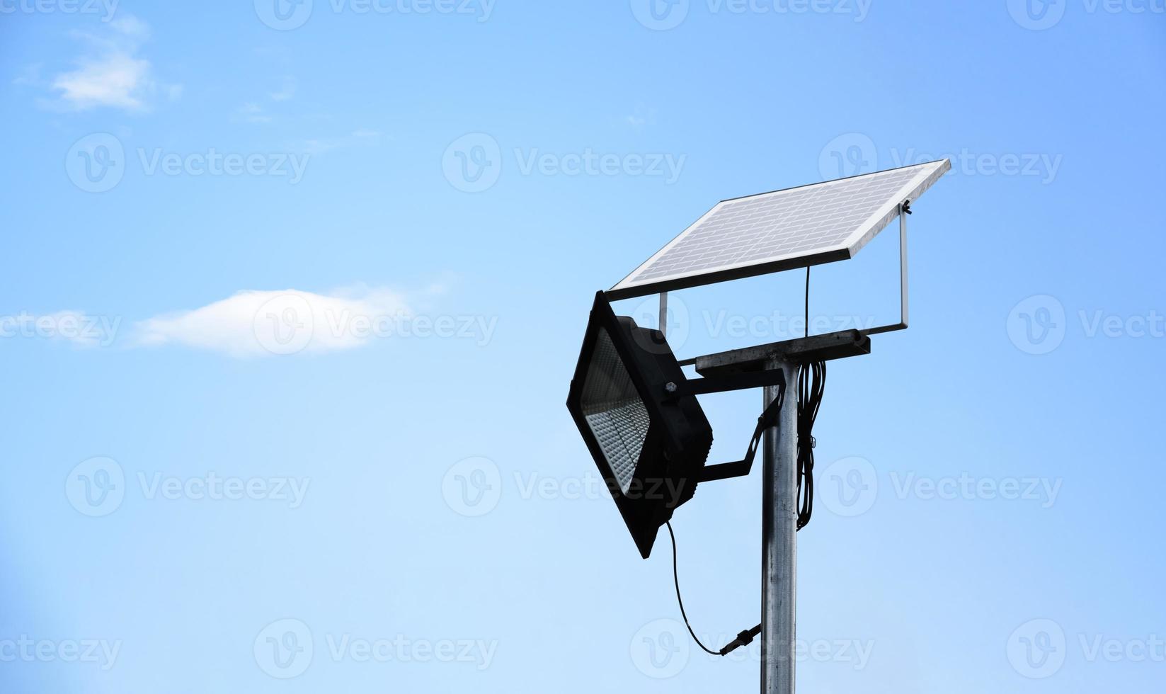 Mini-Solar- oder Photovoltaikzellen-Panel, installiert auf Metallmast mit Flutlicht-LED, verschwommener, bewölkter und blauer Hintergrund, Konzept zur Nutzung natürlicher Energie aus der Sonne im täglichen Leben des Menschen. foto