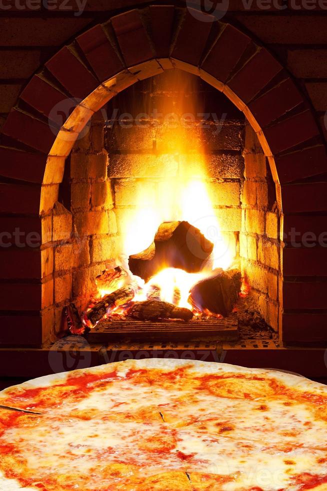 Pizza Margherita und offenes Feuer im Ofen foto