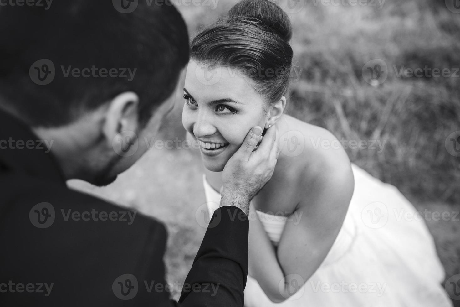 Bräutigam berührt sanft das Gesicht seiner Braut foto