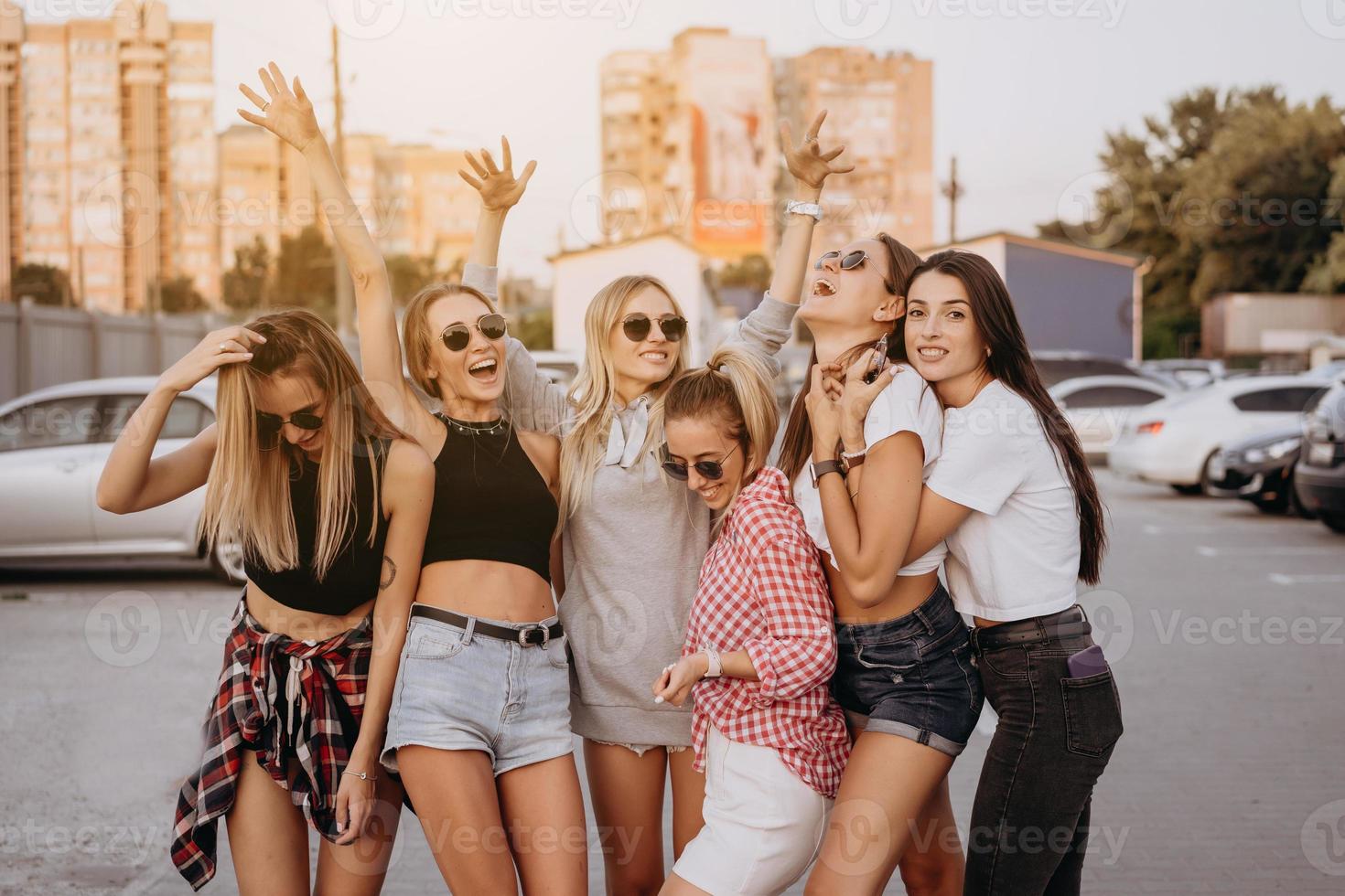 Sechs junge Frauen vergnügen sich auf dem Parkplatz. foto