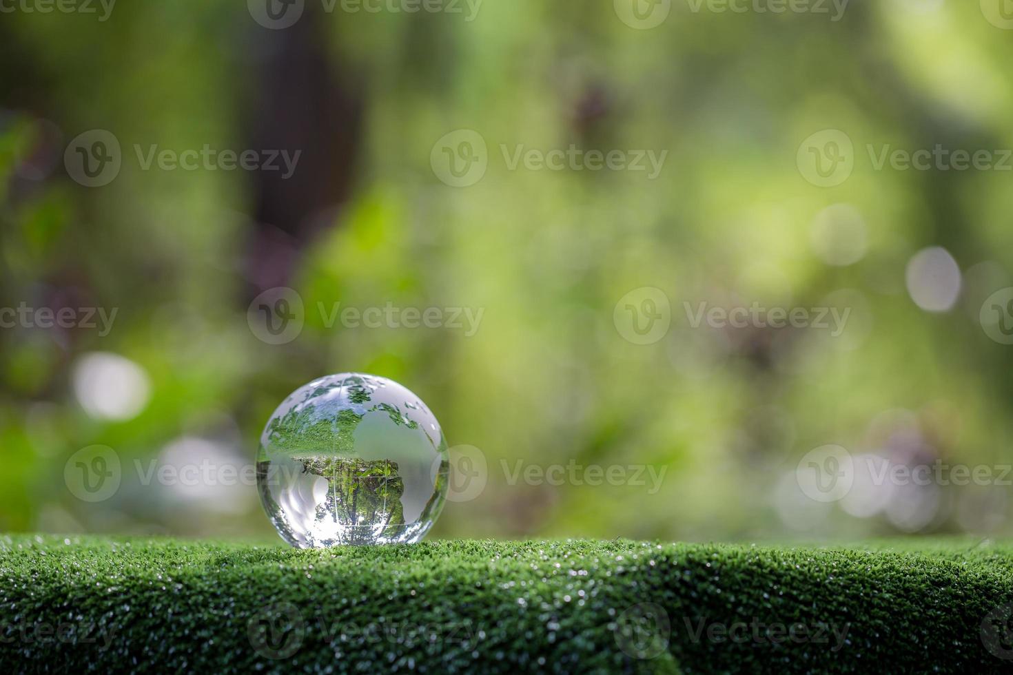 Kugelplanetenglas im grünen Wald mit Bokeh-Naturlichtern. Weltumwelttag. konzept für umweltschutz, schutz der erde und umweltfreundliches leben mit kopierraum foto