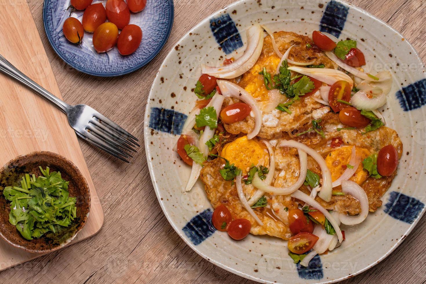 würziger Spiegeleisalat mit Gemüse, Tomaten, Zwiebeln foto