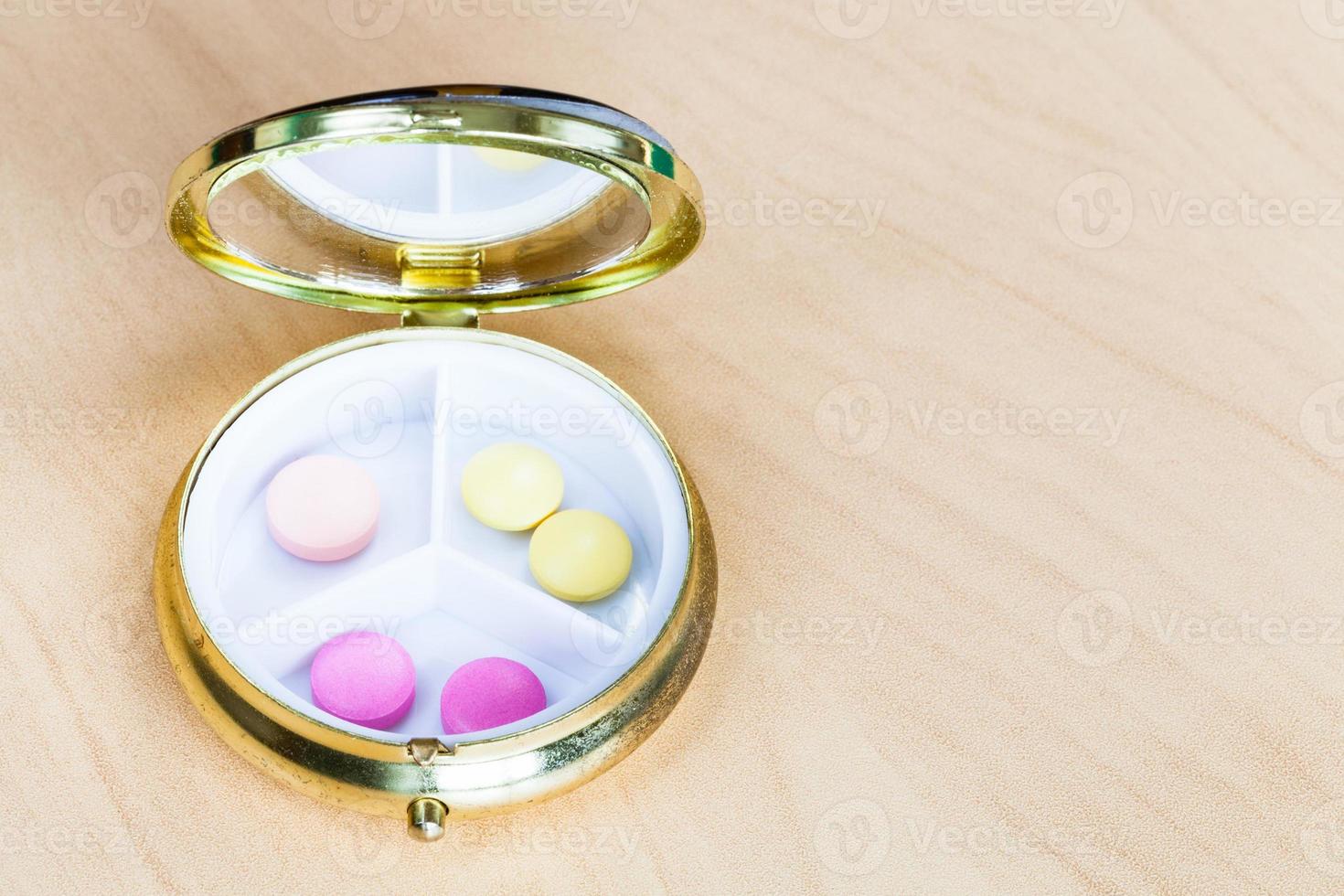 Öffnen Sie die Pillendose mit rosa und gelben Pillen foto