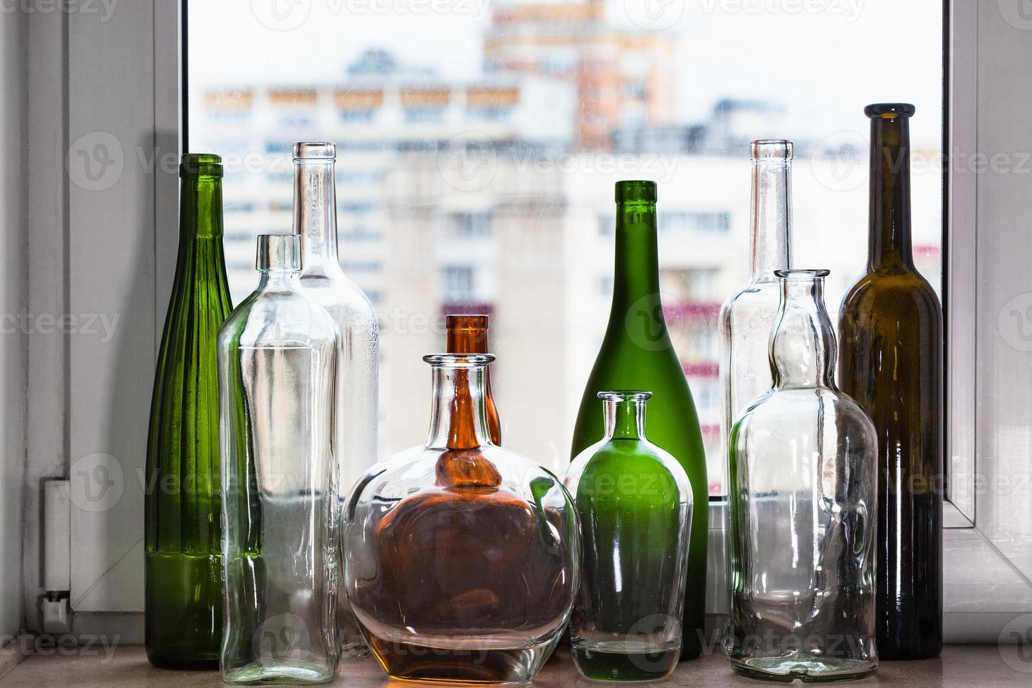 Viele leere Flaschen auf der Fensterbank und Blick auf die Stadt foto