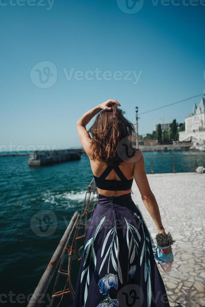 junge hübsche Frau auf dem Pier in der Nähe foto