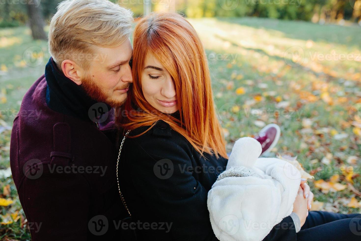 junge Familie und neugeborener Sohn im Herbstpark foto