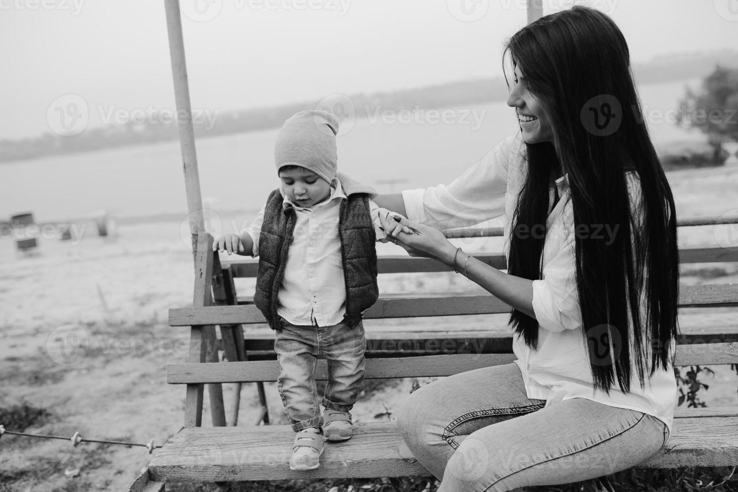 Mutter und kleiner Sohn zusammen auf einer Bank foto