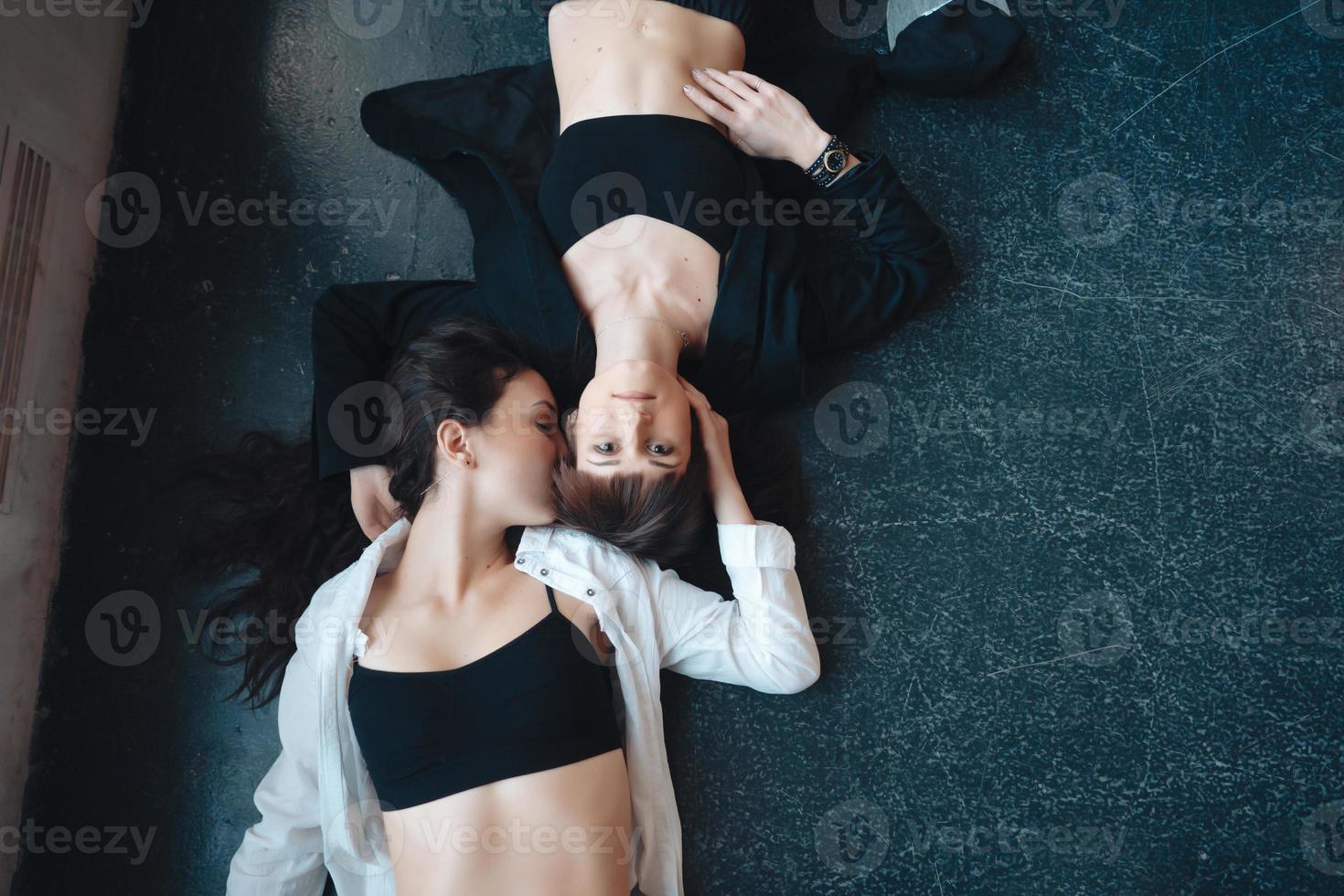 Zwei schöne Mädchen liegen auf dem Boden foto