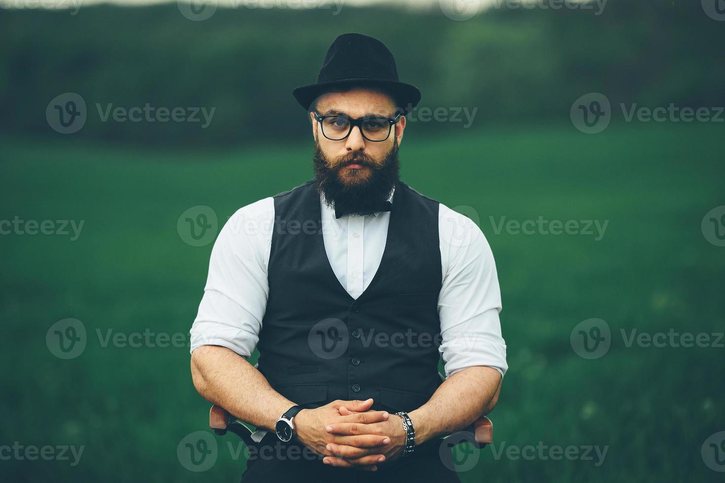 Ein bärtiger Mann, der sich darauf vorbereitet, sich auf dem Feld zu rasieren foto