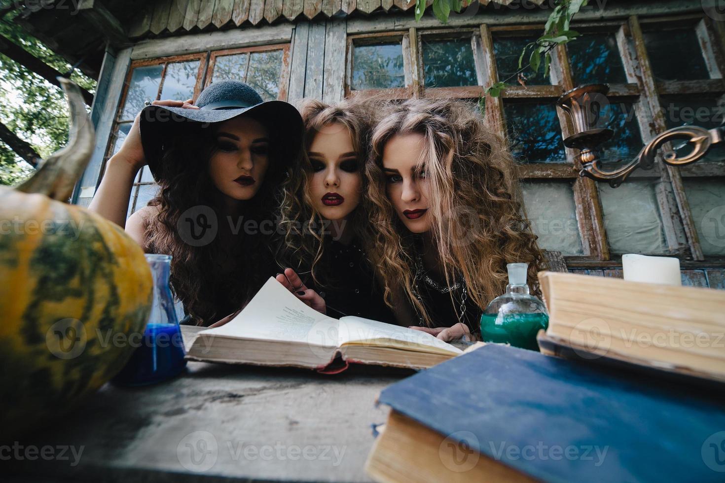 Drei alte Hexen führen ein magisches Ritual durch foto