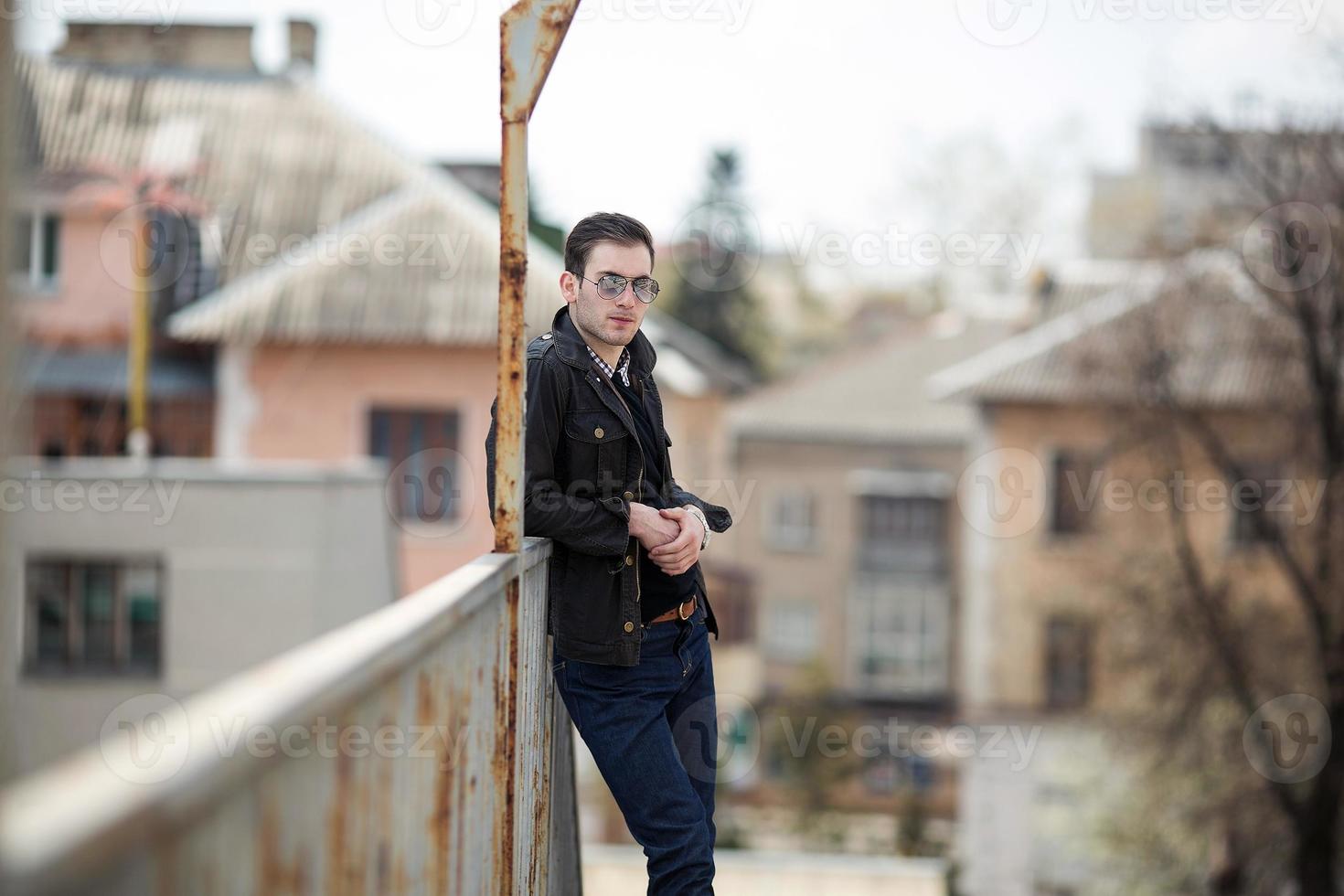 Ein Mann in Jeans im Hintergrund des Zuges und des Bahnhofs foto