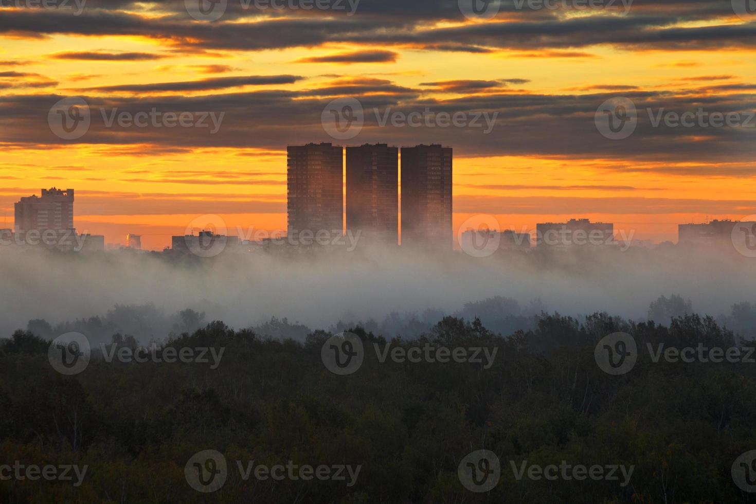 Gelber Sonnenaufgang unter der Stadt im Herbst foto