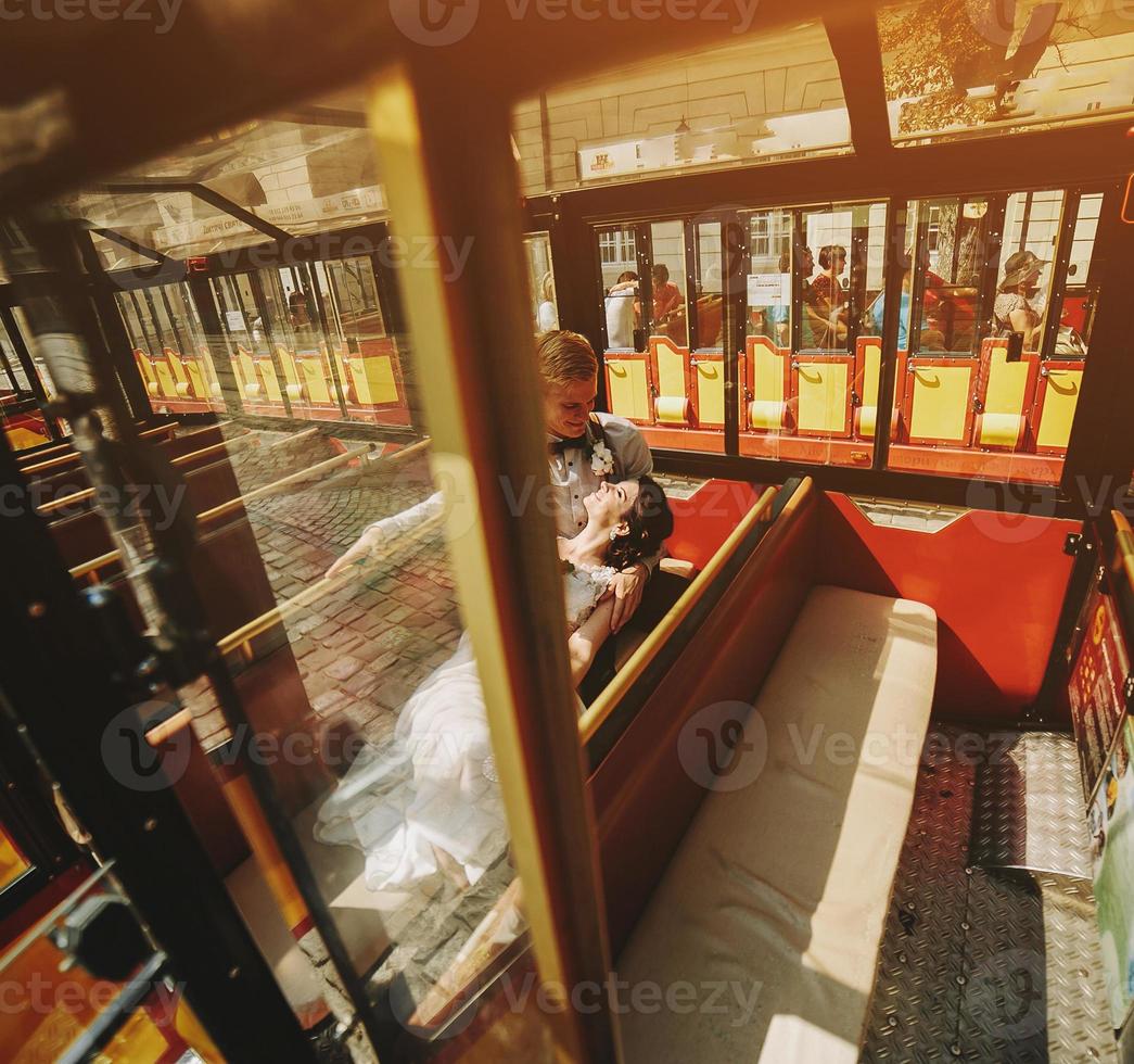 Braut und Bräutigam posieren in einem Tourenwagen foto