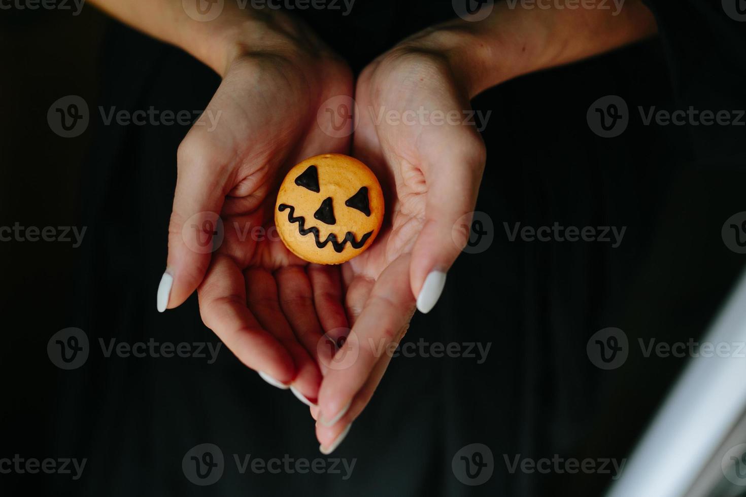 frau, die einen keks für halloween hält foto