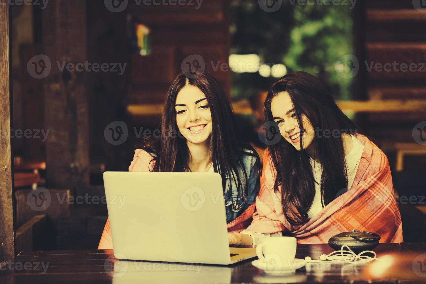 Zwei Mädchen schauen sich etwas im Laptop an foto