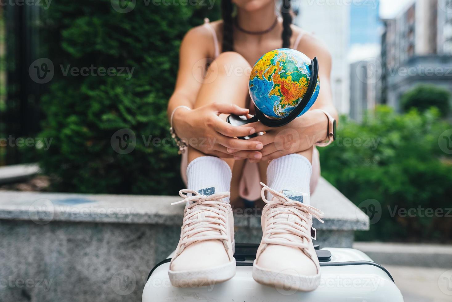 Schöne junge Frau hält einen kleinen Globus in ihren Händen. foto