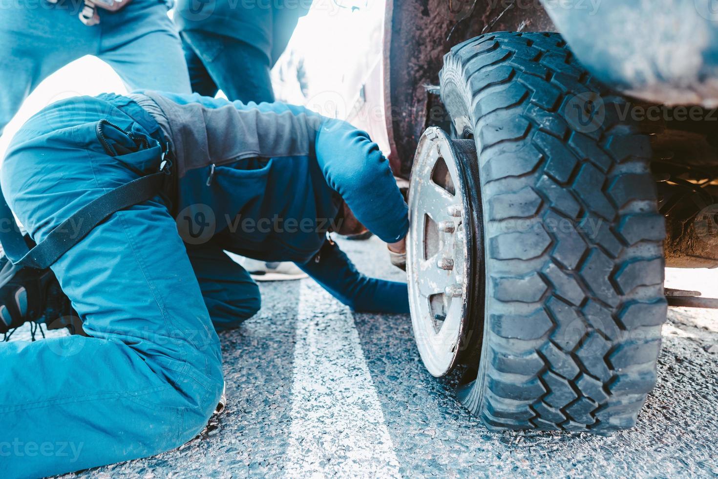 man wechselt das rad manuell auf einem 4x4-geländewagen foto