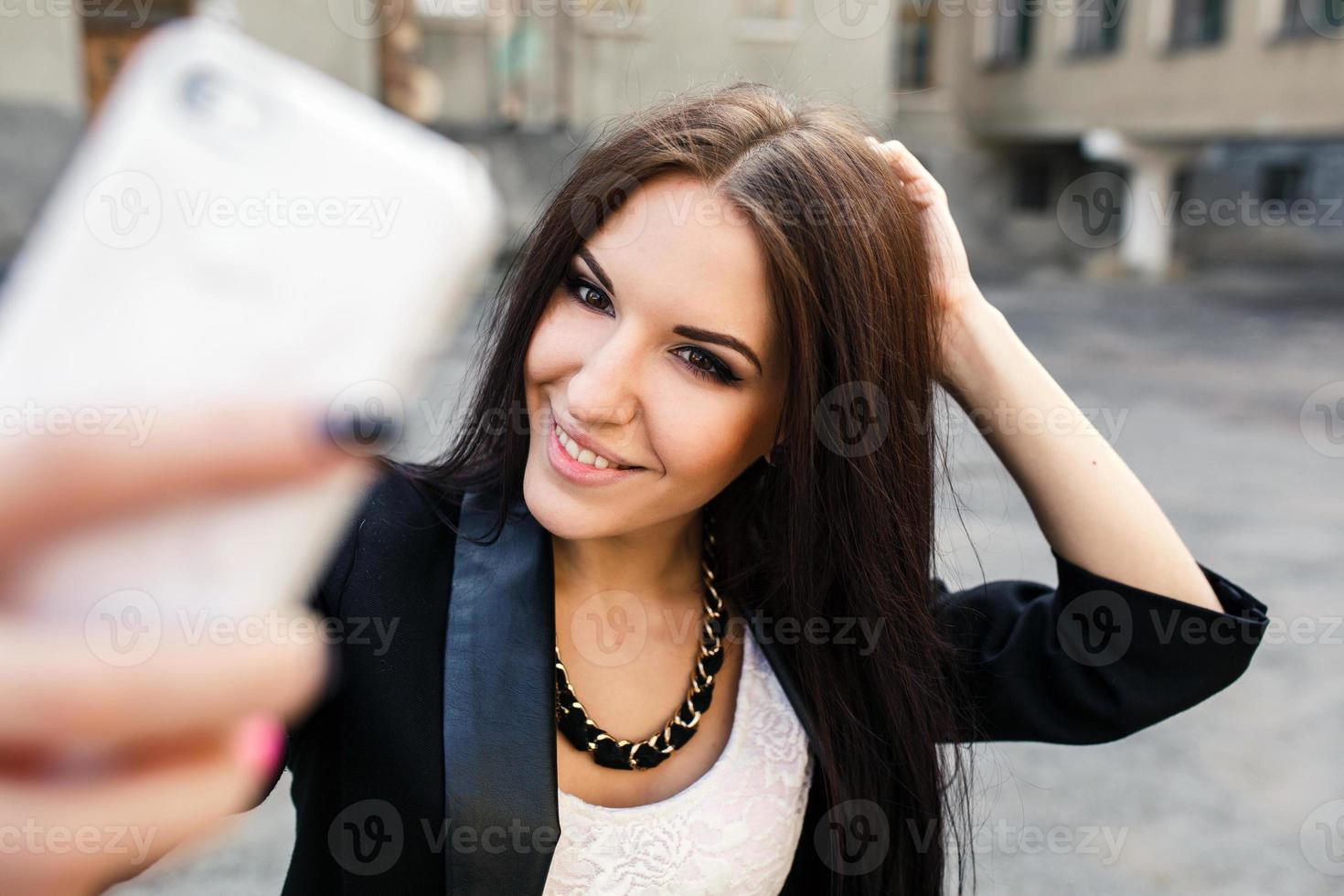 schönes Mädchen macht sich in der Stadt foto