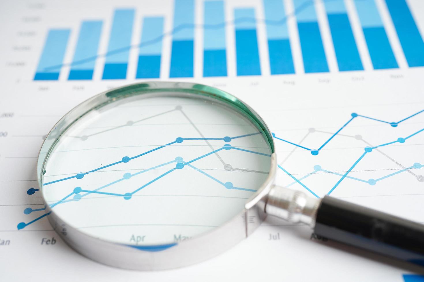 Lupe auf Diagrammen Millimeterpapier. finanzielle Entwicklung, Bankkonto, Statistik, Investitionsanalyse, Forschungsdatenwirtschaft. foto