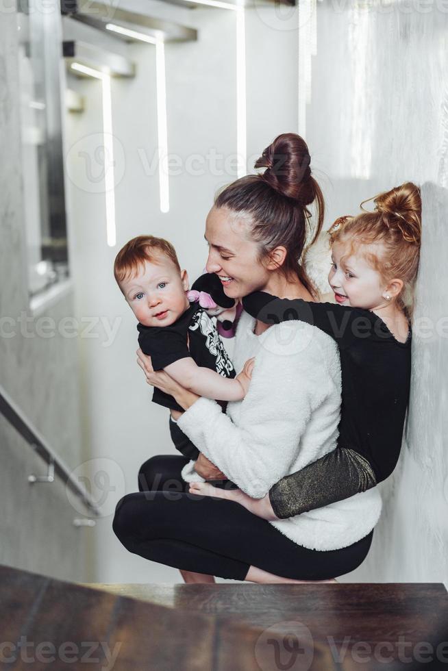 Mutter und Sohn in ihren Armen, Tochter auf dem Rücken foto