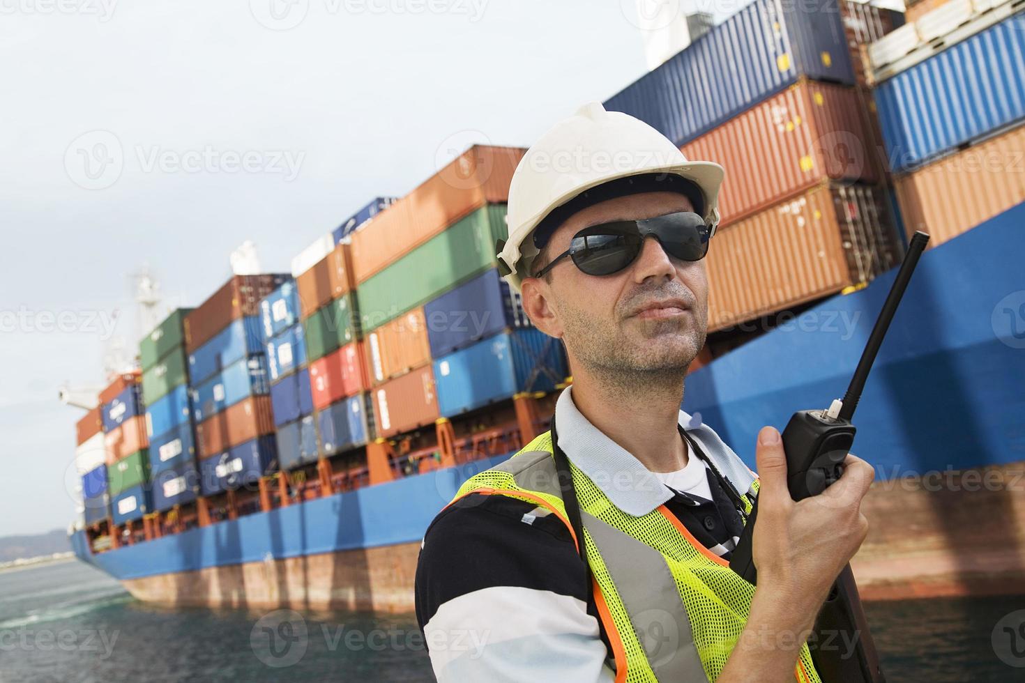 Mann mit Walkie Talkie am Containerterminal foto
