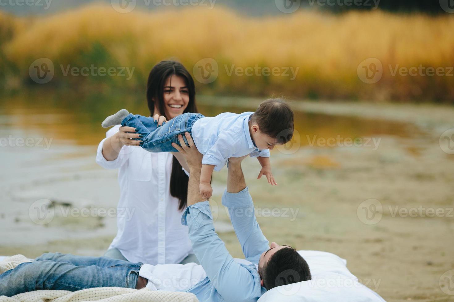 glückliche junge familie, die sich zusammen auf dem see entspannt foto