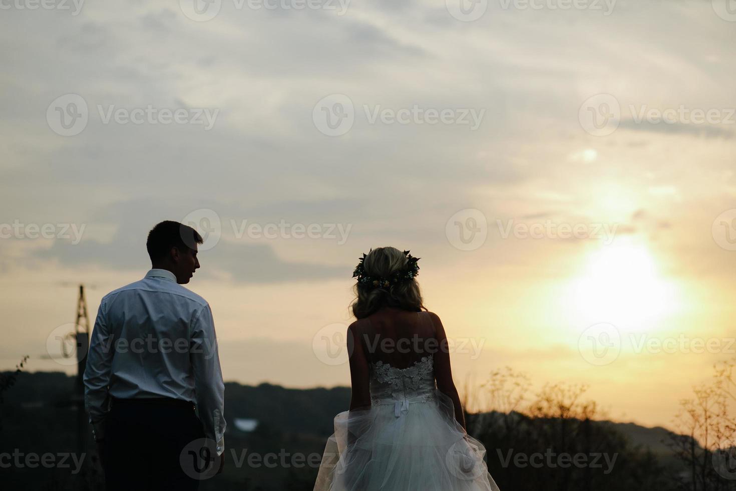 Silhouette des Hochzeitspaares im Feld foto