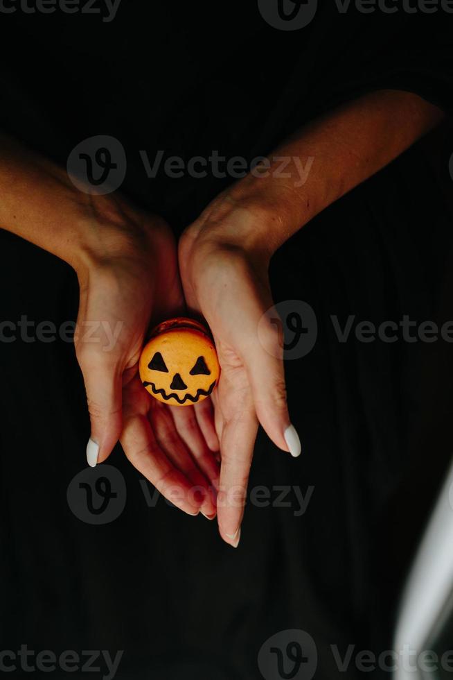 frau, die einen keks für halloween hält foto