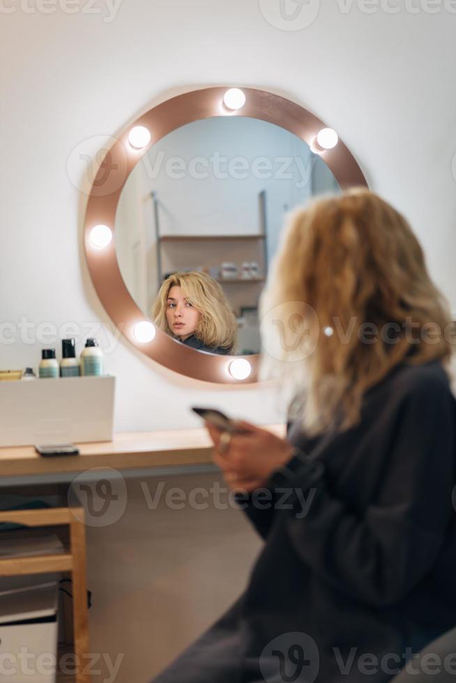 attraktive frau am spiegel im schönheitsstudio foto