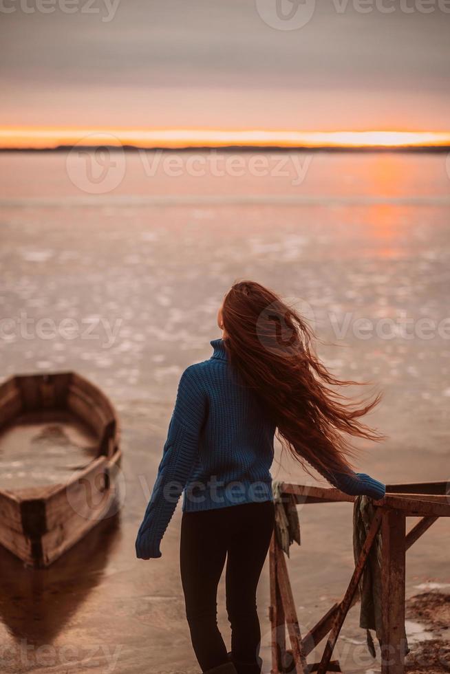 frau, die zeit genießt, sich am schönen see bei sonnenaufgang zu entspannen. foto