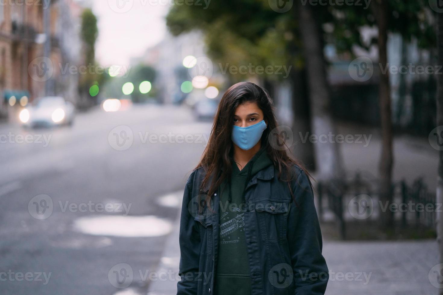 junge frau, person in schützender medizinischer steriler maske auf leerer straße foto