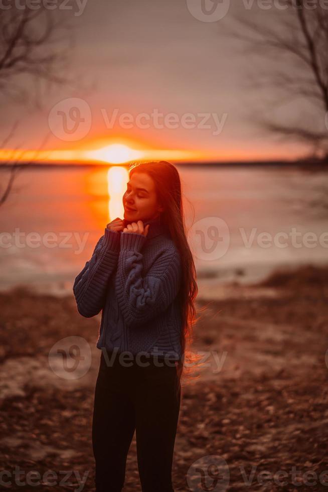 frau, die zeit genießt, sich am schönen see bei sonnenaufgang zu entspannen. foto