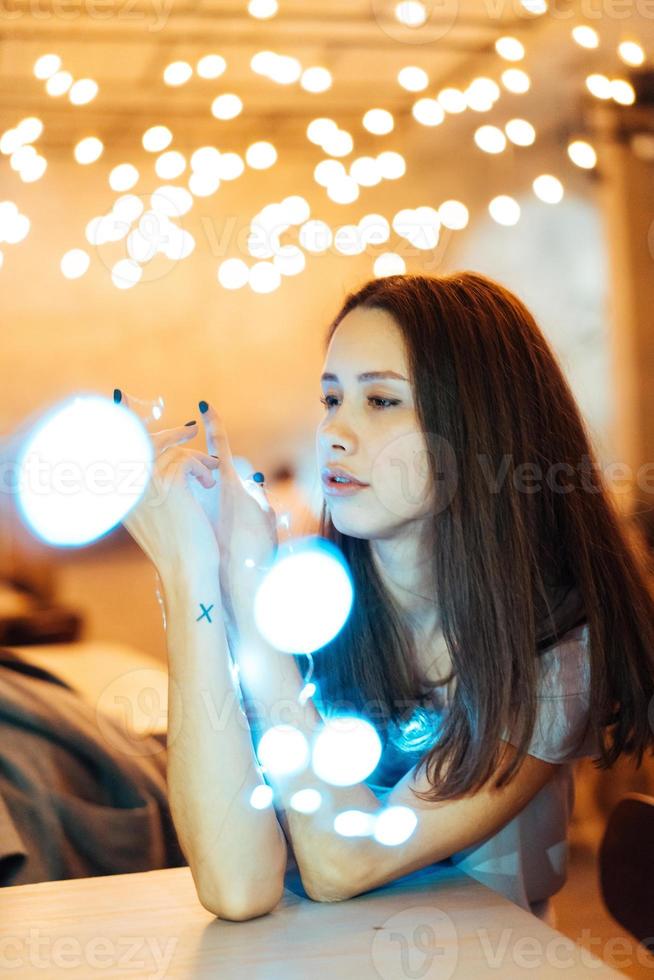 frau, die leuchtende weihnachtsgirlande in den händen hält foto