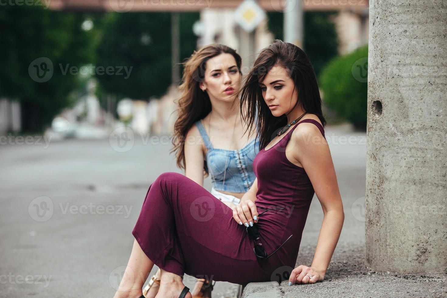 Zwei schöne junge Mädchen posieren in der Stadt foto