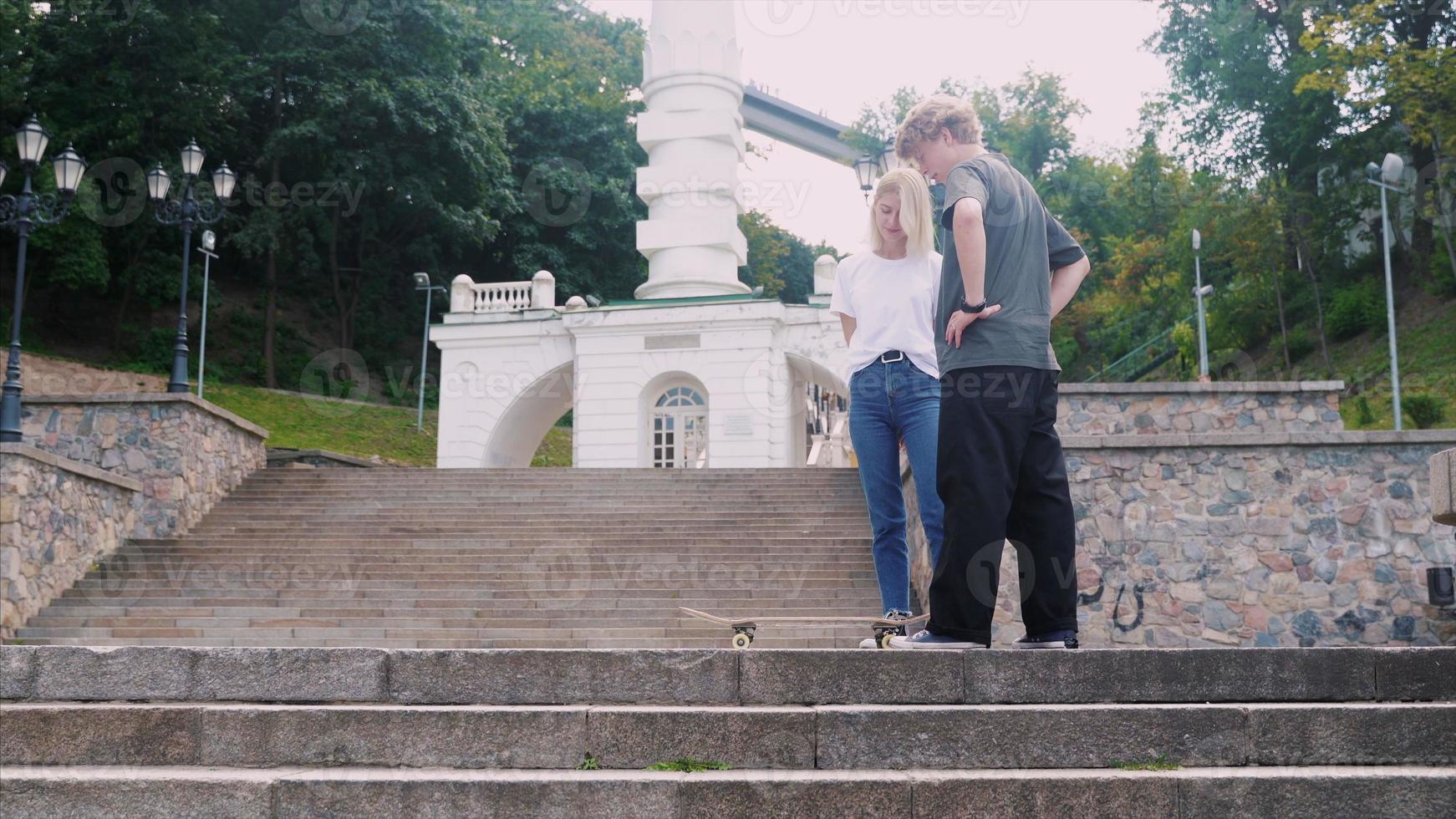 Der Typ bringt seiner Freundin das Skateboarden bei. Datum der Hipster. foto