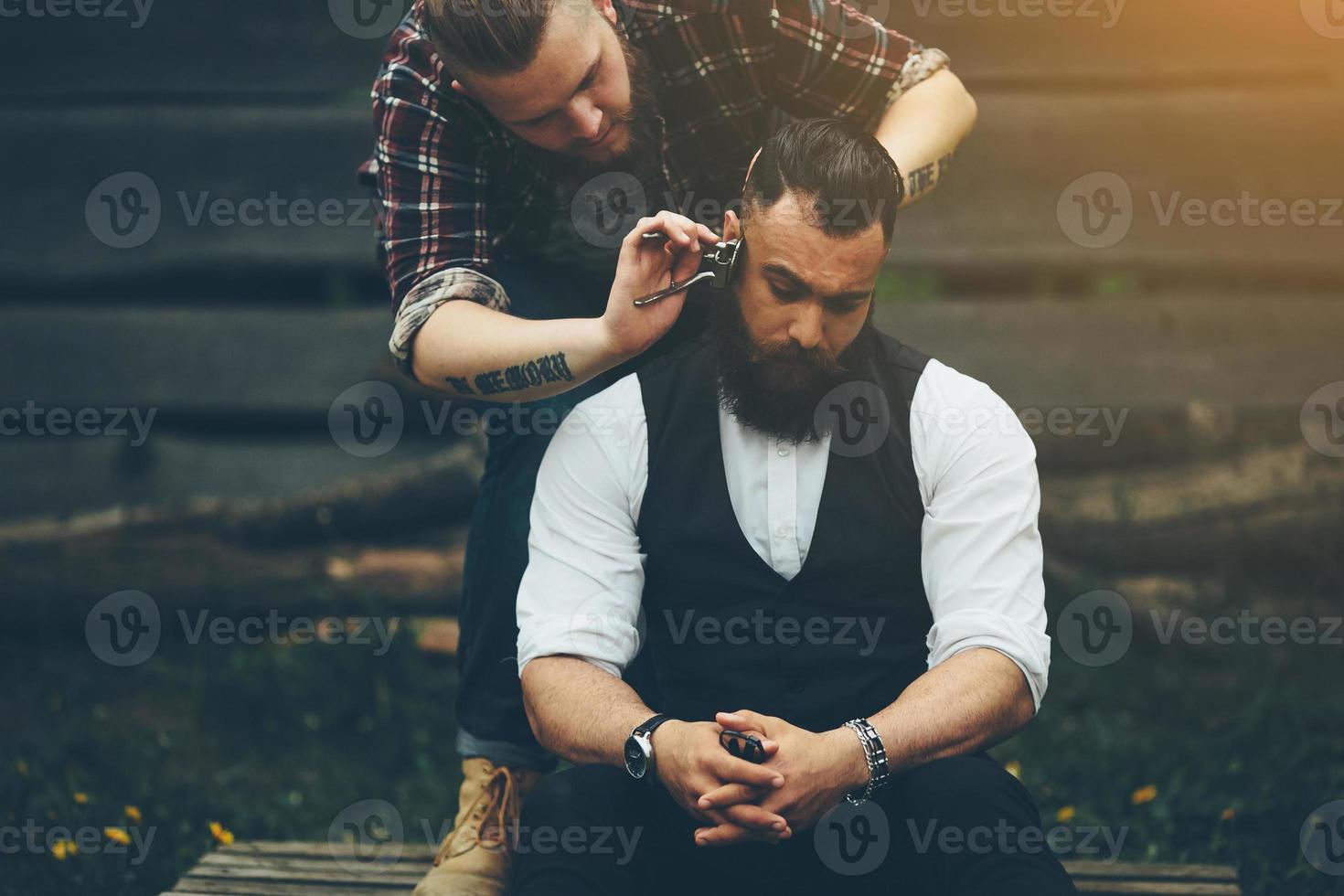 Friseur rasiert einen bärtigen Mann in Vintage-Atmosphäre foto