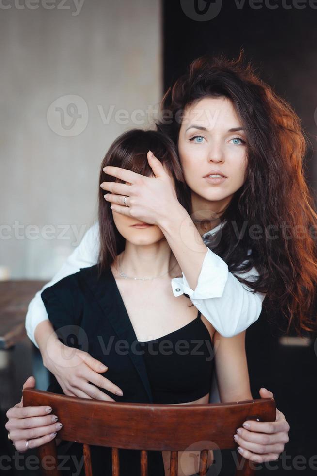 Mädchen hält Hand und schließt die Augen ihrer Freundin foto