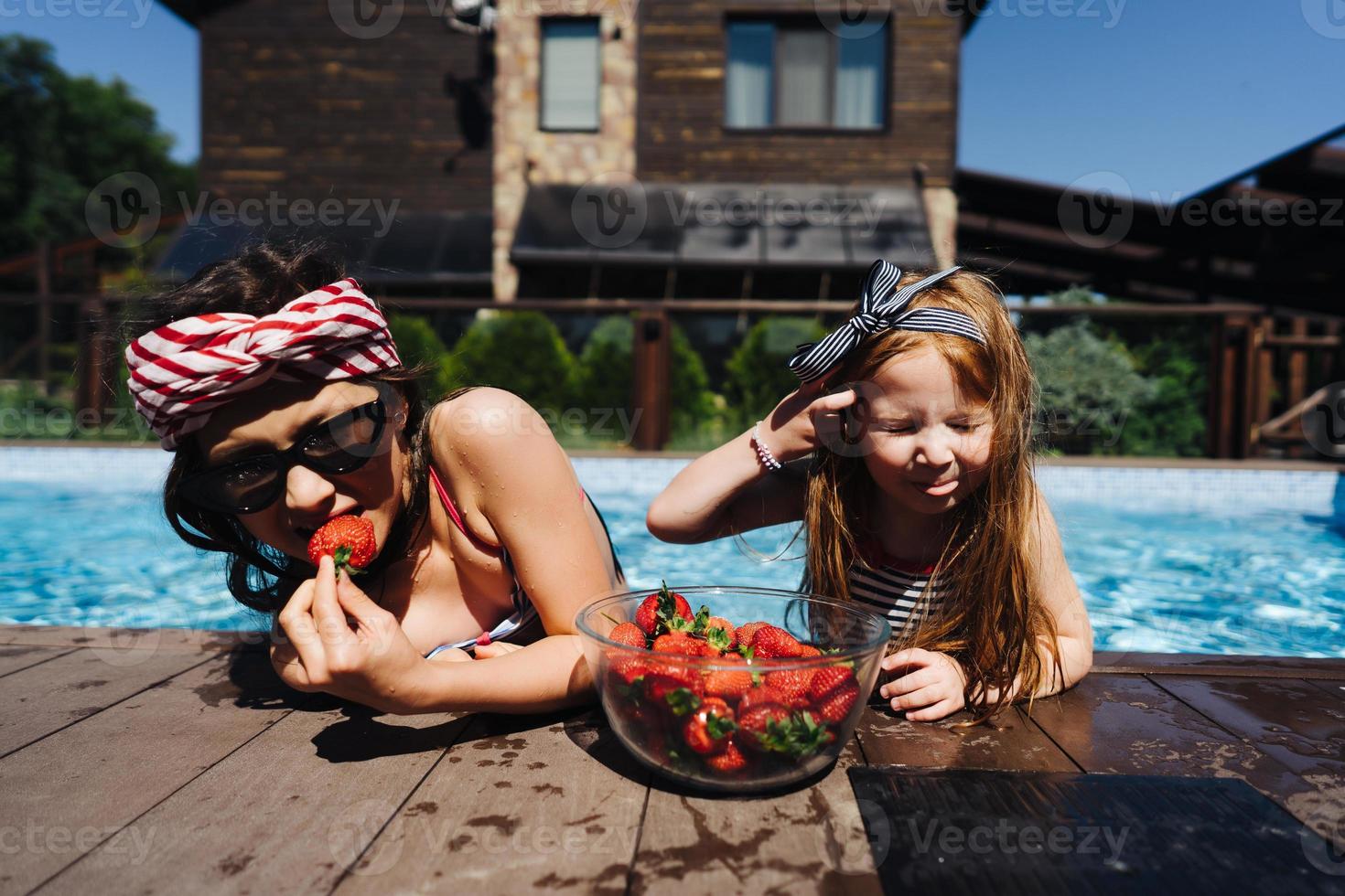 zwei kleine Mädchen auf der Seite des Pools foto