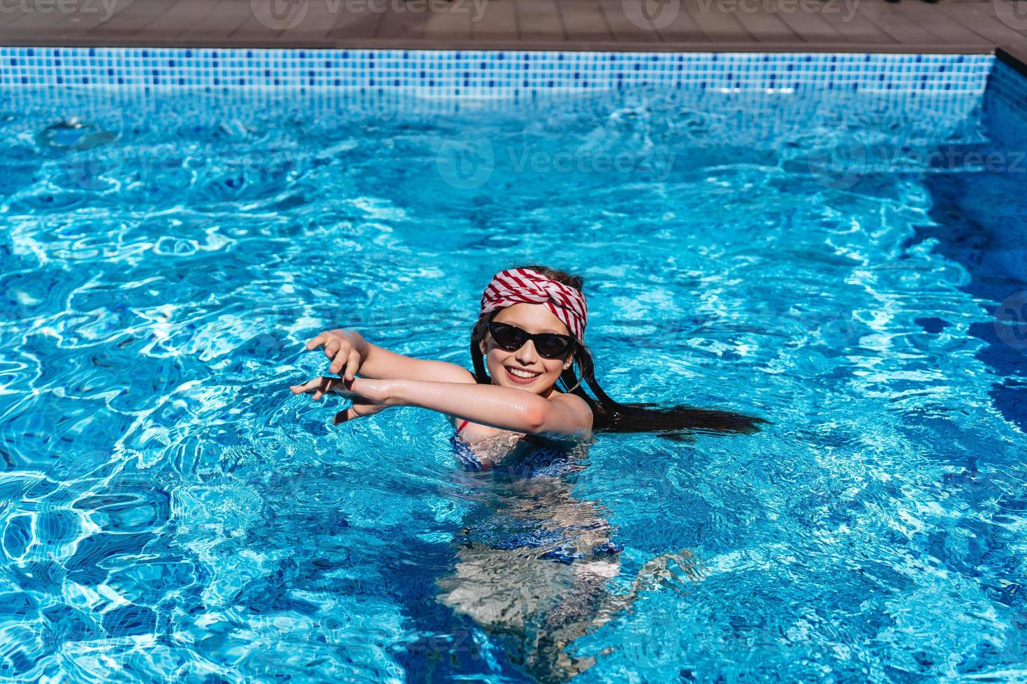 schöne Teenager-Mädchen im Poolwasser entspannen foto