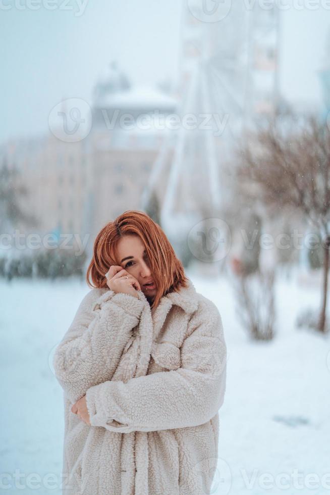 Frau draußen an schneiendem kalten Wintertag foto