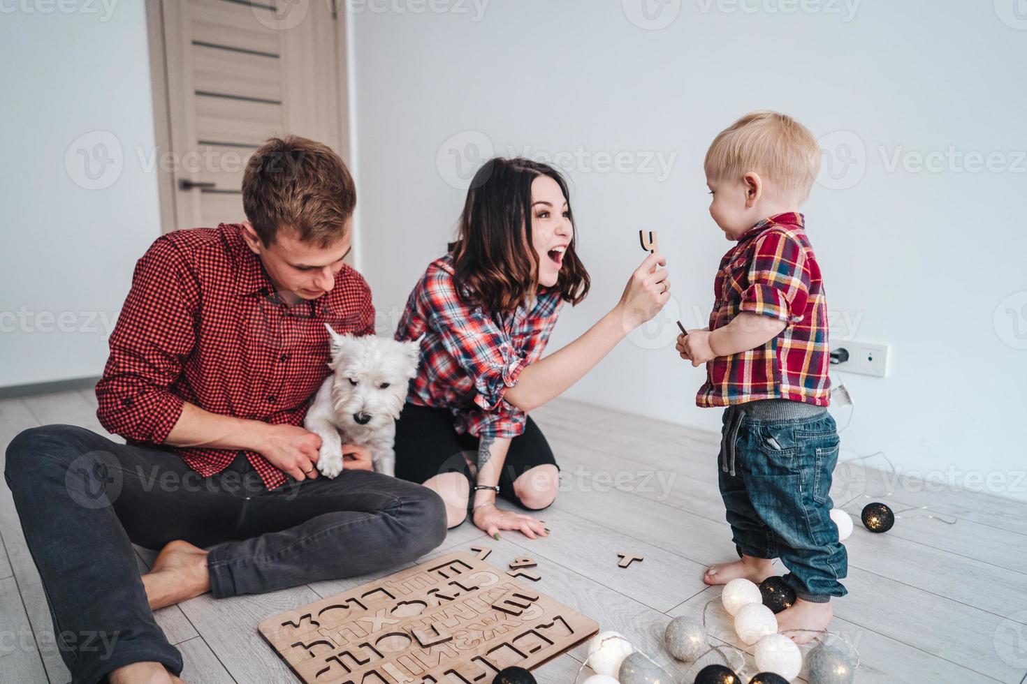 Glückliche Familie spielt zusammen auf dem Boden foto